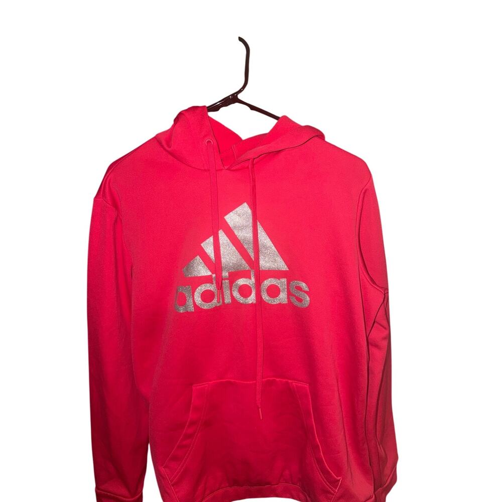 bright pink Adidas pullover hoodie featuring a metallic silver logo on the chest